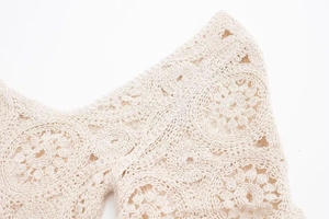 Detail eines Boho-Häkeloberteils mit filigranem Blumen-Spitzenmuster in Cremeweiß
