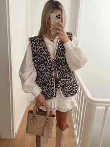 Dettaglio del gilet leopardato con bordo rosa e lacci sopra un top a maniche a sbuffo