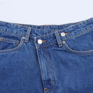 Detail of high waist denim jeans featuring double button closure and contrast stitching