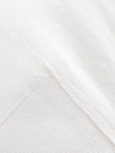 Detailed macro view of white pleated fabric texture with vertical ribbed knit structure