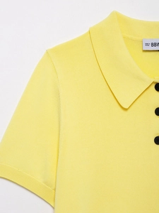 Gros plan du polo en maille jaune vif montrant le col côtelé et la texture détaillée
