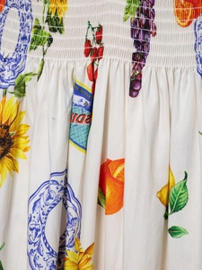 Detail der gesmokten Taille mit Sonnenblumen- und Zitrusfrüchtedruck auf Wollweiß