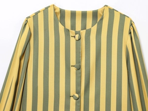 Detail of yellow and green striped shirt with fabric-covered buttons and puff sleeves