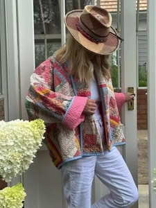 Detail of bohemian patchwork quilted jacket with floral patterns and pink trim on cuffs
