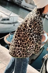 Detail view of leopard print quilted jacket featuring olive green piping and large pockets