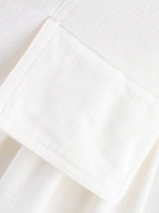 Detailed close-up of white twill cotton fabric with clean stitching on the pocket edge
