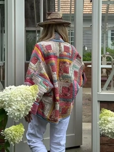 Back view of a colorful quilted patchwork jacket featuring vibrant geometric patterns