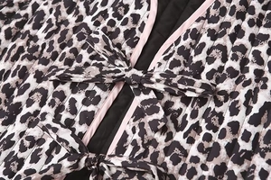 Vista dettagliata del gilet trapuntato leopardato con bordi rosa e chiusure a fiocco sottili