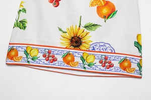 Détail du tissu à imprimé fleurs et agrumes avec bordure à motif bleu