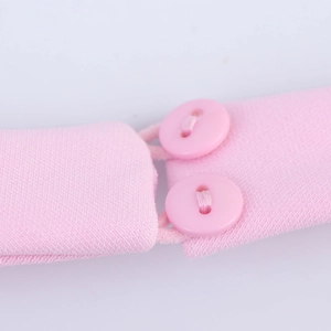 Detail of pink fabric straps featuring two round buttons and elastic loops on a top