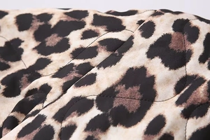 Detailed macro view of quilted leopard print fabric with precise diamond stitching texture