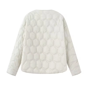 Detail of light beige quilted jacket showing unique hexagonal honeycomb stitching pattern