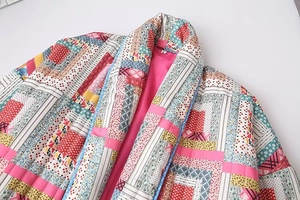 Detailed close-up of quilted patchwork jacket with floral patterns and pink lining