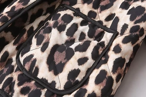 Detailed macro view of quilted leopard print jacket with wave stitching and black piping