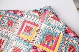 Close-up of quilted floral fabric patterns and detailed stitching on a women's jacket
