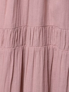 Detail of pink pleated tulle fabric showing vertical texture and layered ruffles