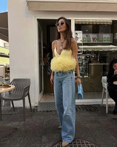 Detail of yellow tulle peplum top and wide-leg denim jeans in a chic street style look