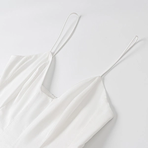 Détail du décolleté carré et fines bretelles spaghetti sur robe d'été en popeline blanche