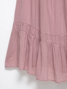 Detailed macro of dusty rose midi dress featuring pleated ruffles and textured cotton fabric