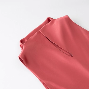 Detailed close-up of coral pink satin dress with elegant stand collar and silky finish