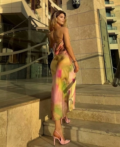 Detail of cross-back straps on backless rainbow print satin midi dress in sunset light