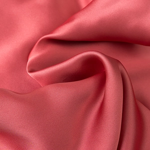Detail of elegant satin fabric in dusty rose with subtle twill texture and silky drape