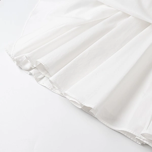 Détail de la robe courte en popeline blanche avec ourlet plissé et finitions de haute qualité