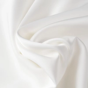 Close-up of white silk satin fabric with elegant folds and soft pearlescent luster