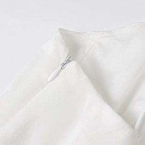 Vue détaillée de la fermeture éclair invisible et des coutures sur la robe en popeline