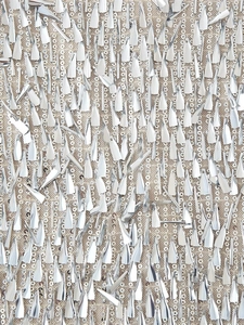 Detailed macro view of silver sequins and hanging metallic fringe on mesh fabric