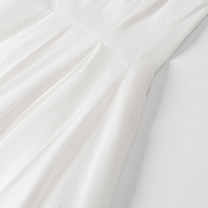 Vue détaillée du tissu en popeline blanche avec plis verticaux et coutures latérales