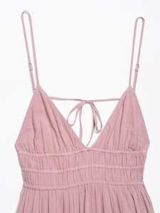 Detail of dusty pink tulle midi dress featuring tie-back bow and smocked waistline