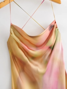 Detail of cowl neck satin dress with abstract tie-dye print and thin cross straps