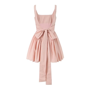Pink backless A-line dress featuring a large bow tie design and pleated flared skirt