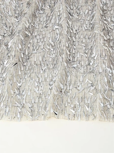 Detailed macro view of silver metallic triangle sequins on champagne mesh fabric skirt