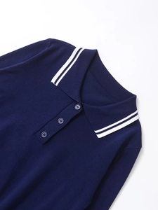 Détail d'un polo en tricot bleu marine avec col à rayures blanches et patte à trois boutons