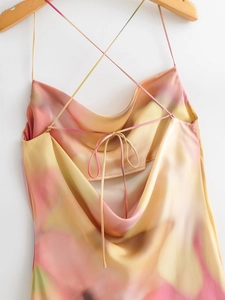 Detail of summer tie-dye satin dress featuring criss-cross backless design and thin straps
