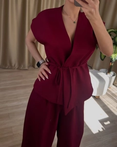Detail view of burgundy sleeveless wrap top with tie waist and matching wide leg pants