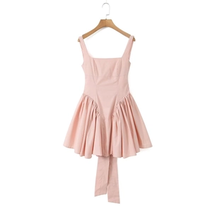 Pink A-line dress with square neck and bow tie back detail hanging on wood hanger