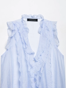 Detail of light blue sleeveless shirt featuring a ruffled V-neck and delicate white buttons