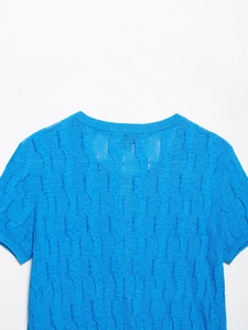Detailed view of royal blue short-sleeve knitwear with vertical wavy textured pattern