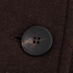 Macro shot of dark brown tweed coat texture with detailed marble pattern button