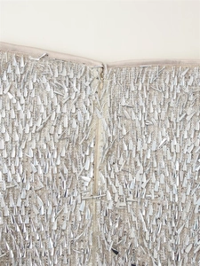 Macro view of silver sequins and metallic fringe beads with a hidden zipper detail
