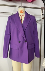 Detailed close-up of purple double-breasted blazer showing lapel and flap pockets