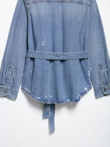 Rear view of blue denim jacket showing waist belt and distressed ripped details on fabric