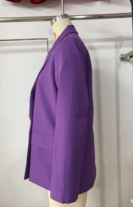 Detail view of purple double-breasted blazer with notch lapels and flap pockets