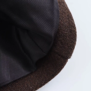 Detailed close-up of dark brown wool coat fabric with high-quality black lining