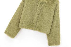 Détail d'une veste courte en fausse fourrure vert herbe avec une texture douce et dense