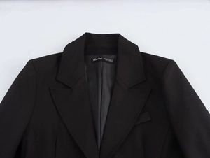 Detail view of the notch lapel and interior collar label of this women's black blazer