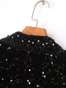 Detailed close-up of a black sequin blazer collar and high-quality sewing craftsmanship